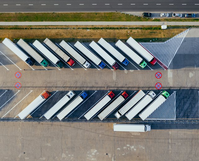 Aerial view of semi trucks parked in rows at a freight yard