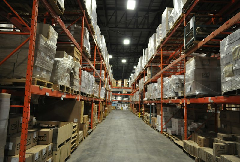 Warehouse aisle with tall racks full of palletized boxes
